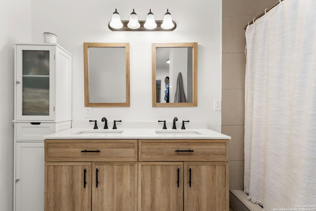 bathroom with double vanity, a shower with shower curtain, and a sink