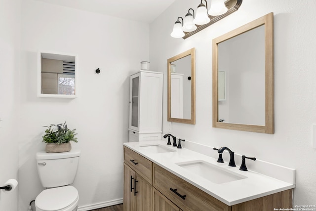 full bathroom featuring double vanity, a sink, and toilet