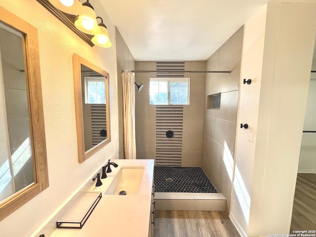 full bathroom with a shower stall, vanity, and wood finished floors