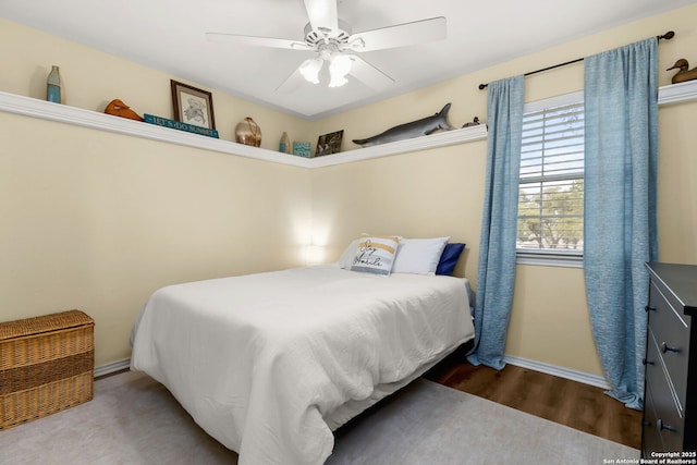 bedroom with ceiling fan, baseboards, and wood finished floors