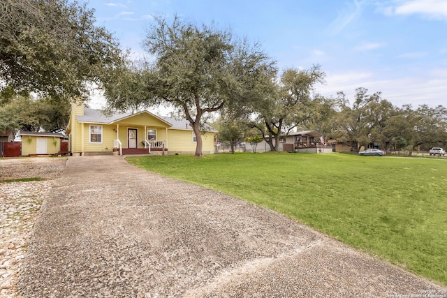 ranch-style house featuring driveway and a front lawn