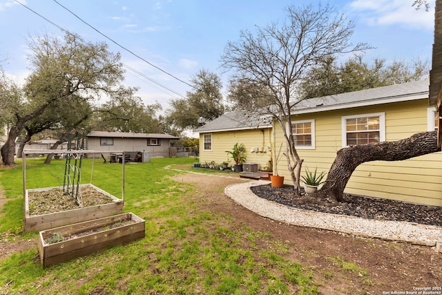 view of yard featuring cooling unit, a vegetable garden, and fence