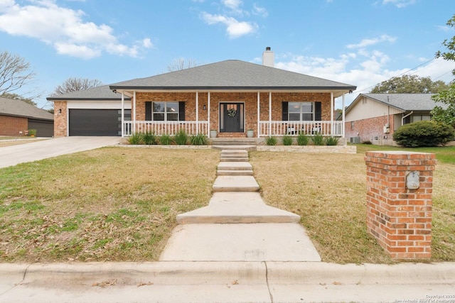 view of front of home featuring a front yard, covered porch, brick siding, and driveway