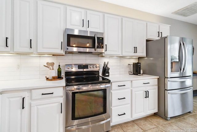 kitchen featuring stainless steel appliances, light countertops, visible vents, and white cabinetry