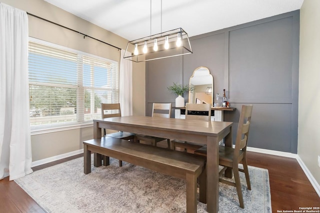 dining area featuring dark wood-type flooring and baseboards