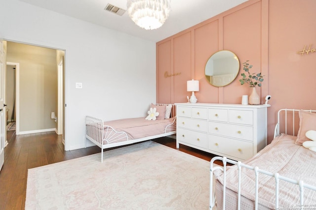 bedroom featuring dark wood-style flooring, visible vents, and baseboards