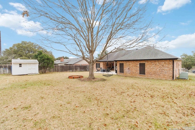 view of yard with a storage shed, a fenced backyard, and an outdoor structure