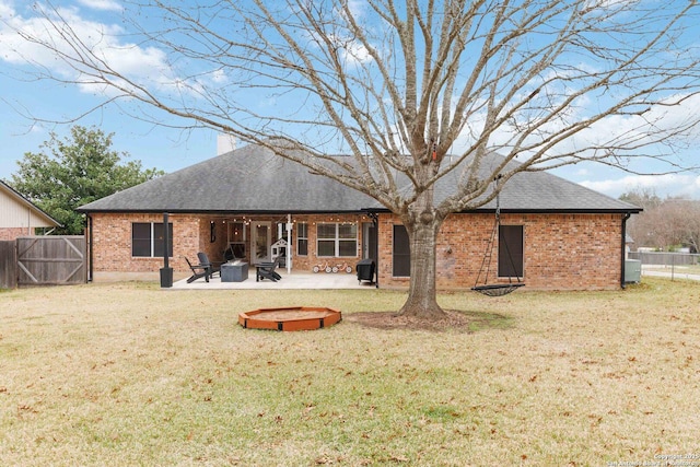 back of property featuring brick siding, a lawn, and a patio area