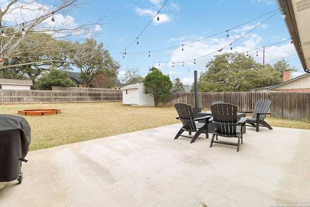 view of patio / terrace with a grill, a storage unit, a fenced backyard, and an outdoor structure