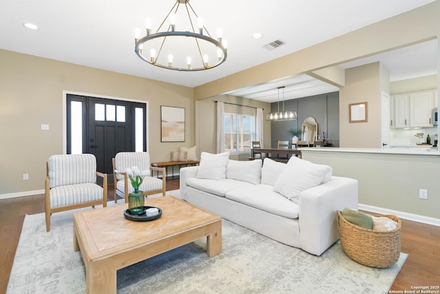 living room with a notable chandelier, recessed lighting, visible vents, light wood-style floors, and baseboards