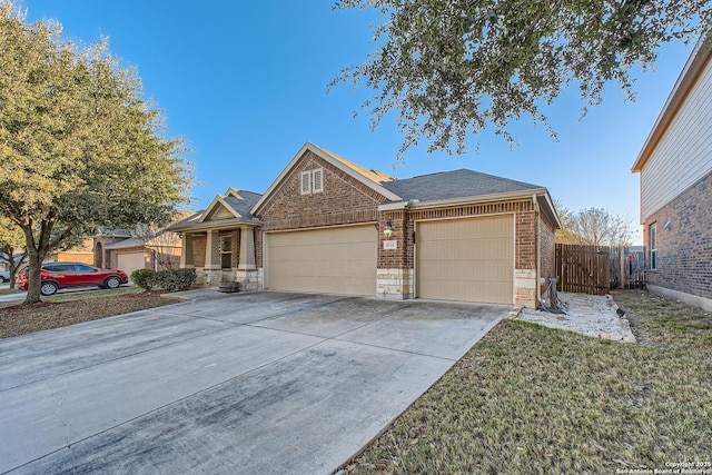 ranch-style home featuring a garage, concrete driveway, brick siding, and stone siding