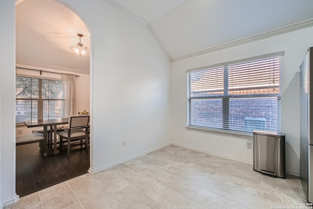 empty room with arched walkways, ornamental molding, vaulted ceiling, and plenty of natural light