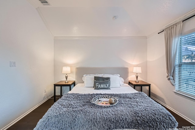 bedroom with ornamental molding, dark wood-style flooring, visible vents, and baseboards