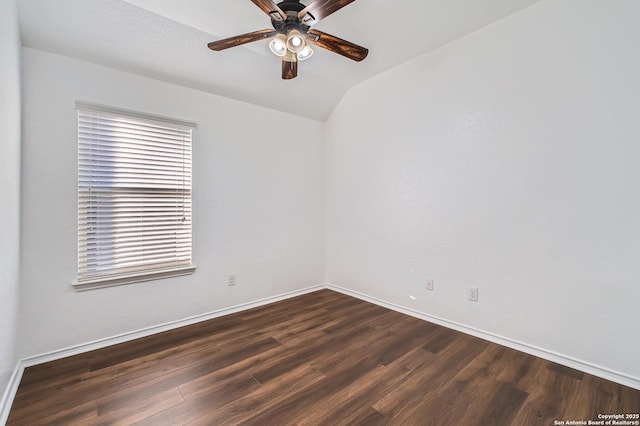 spare room with vaulted ceiling, dark wood finished floors, baseboards, and ceiling fan