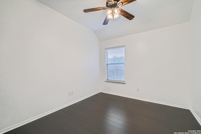 empty room with dark wood-type flooring, vaulted ceiling, baseboards, and ceiling fan