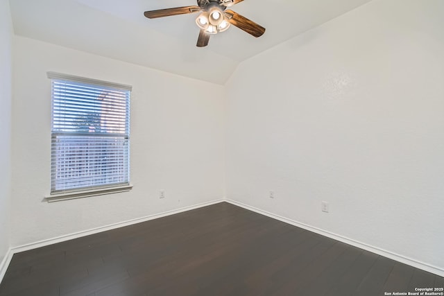 spare room with a ceiling fan, baseboards, vaulted ceiling, and dark wood-style flooring