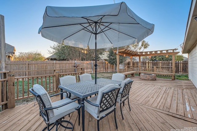 deck featuring outdoor dining space, a fenced backyard, a fire pit, and a pergola