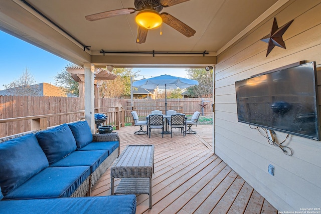 deck featuring ceiling fan, outdoor lounge area, a fenced backyard, and outdoor dining space