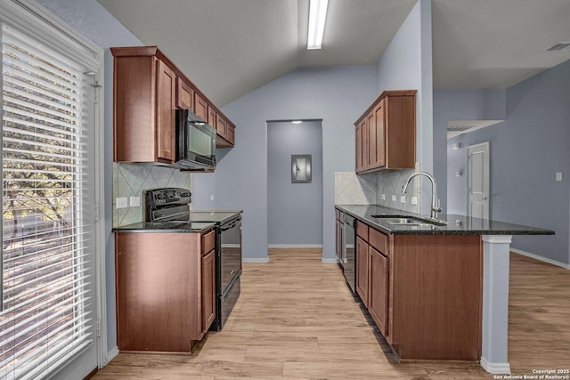 kitchen with lofted ceiling, a sink, brown cabinets, dark stone counters, and black appliances