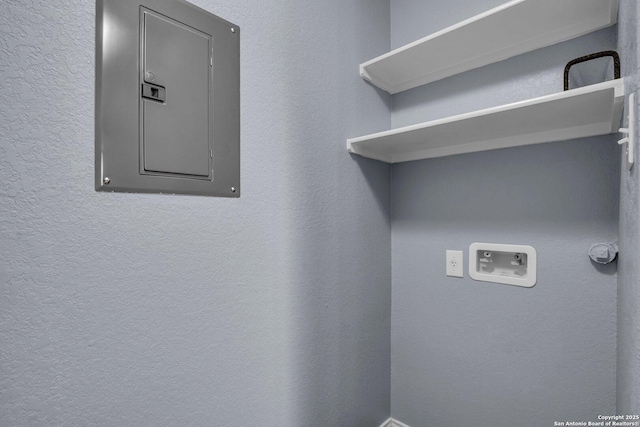 washroom featuring laundry area, electric panel, washer hookup, and a textured wall