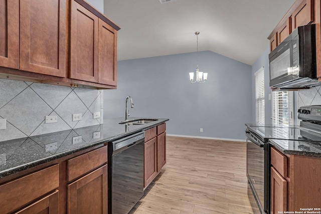 kitchen featuring black appliances, dark stone countertops, a sink, and brown cabinets