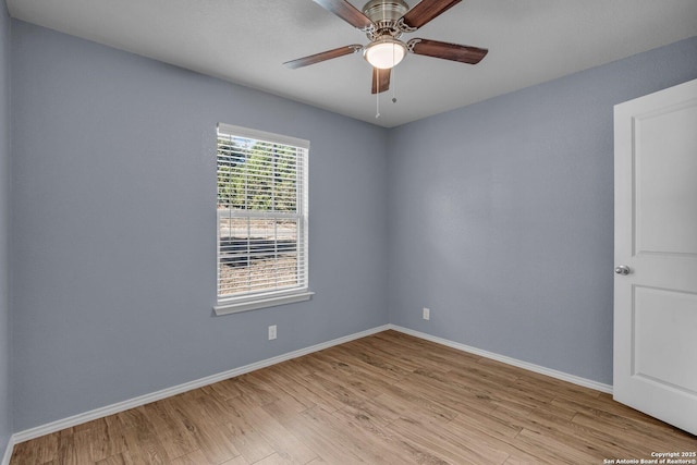 spare room featuring light wood finished floors, baseboards, and a ceiling fan