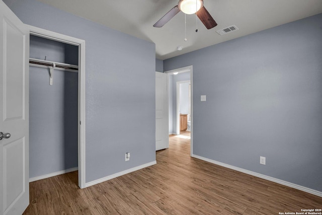 unfurnished bedroom with light wood-style flooring, a closet, visible vents, and baseboards