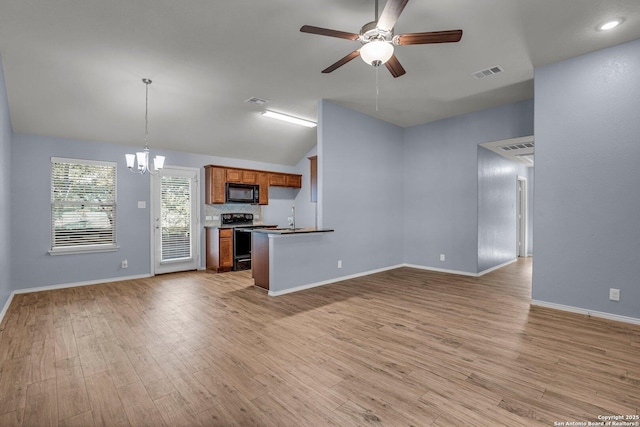 kitchen with black microwave, open floor plan, electric stove, brown cabinets, and pendant lighting