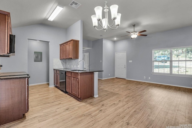 kitchen with pendant lighting, brown cabinets, dark countertops, visible vents, and a sink