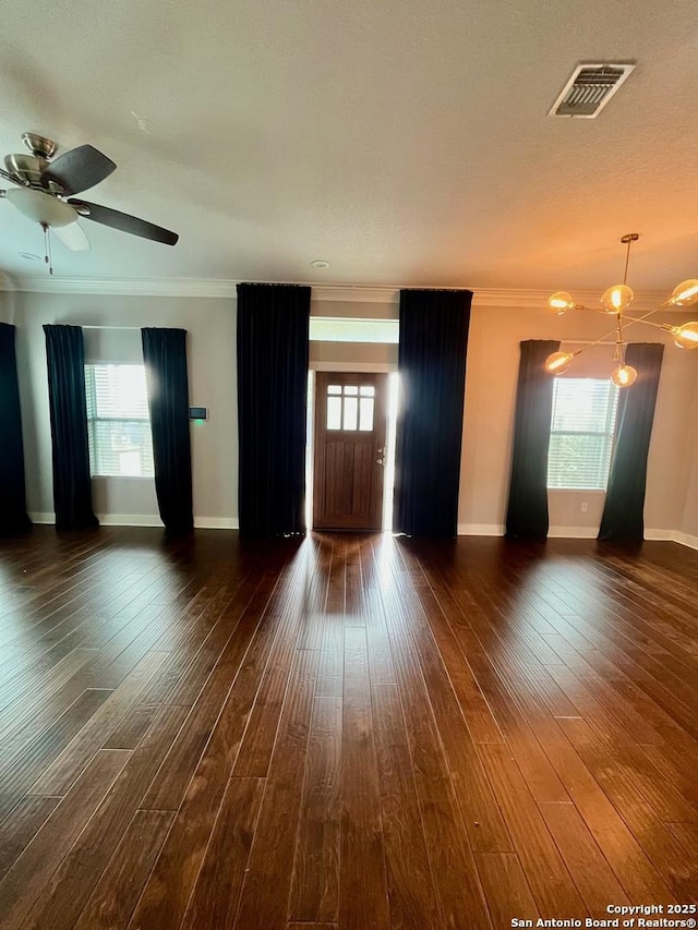 unfurnished living room featuring baseboards, crown molding, visible vents, and dark wood-style flooring