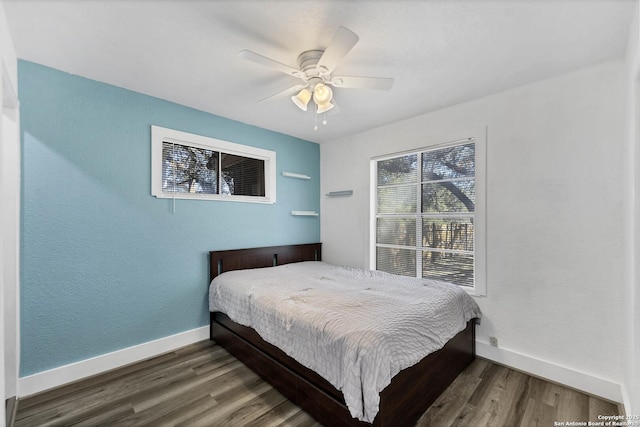 bedroom with baseboards, wood finished floors, and a ceiling fan