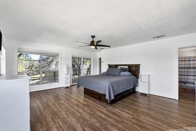 bedroom featuring access to exterior, visible vents, dark wood finished floors, a textured ceiling, and a ceiling fan