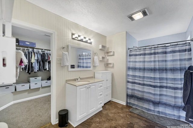 full bath featuring visible vents, curtained shower, baseboards, vanity, and a textured ceiling