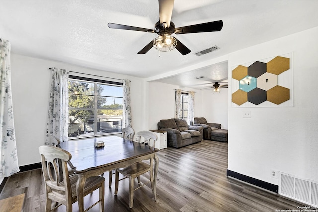 dining room featuring visible vents, a textured ceiling, baseboards, and dark wood-style flooring