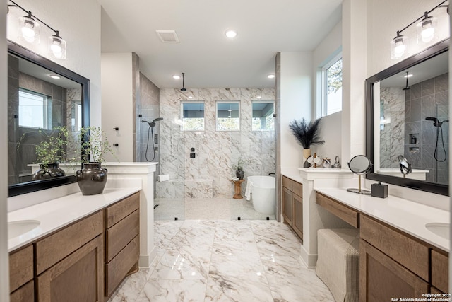 full bath with a walk in shower, a freestanding tub, recessed lighting, two vanities, and marble finish floor