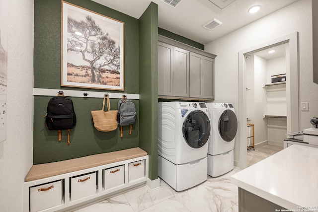 clothes washing area with marble finish floor, cabinet space, visible vents, and separate washer and dryer