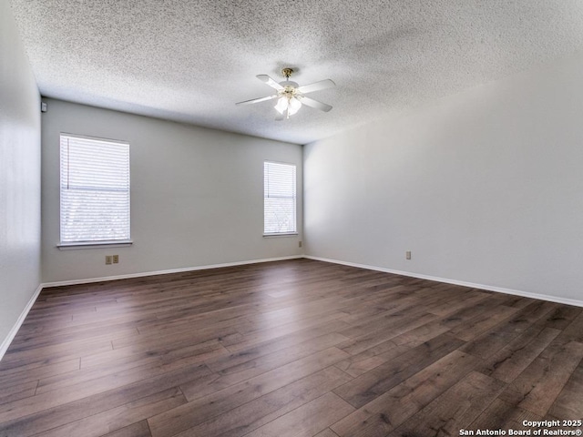 unfurnished room with baseboards, a textured ceiling, a ceiling fan, and dark wood-type flooring