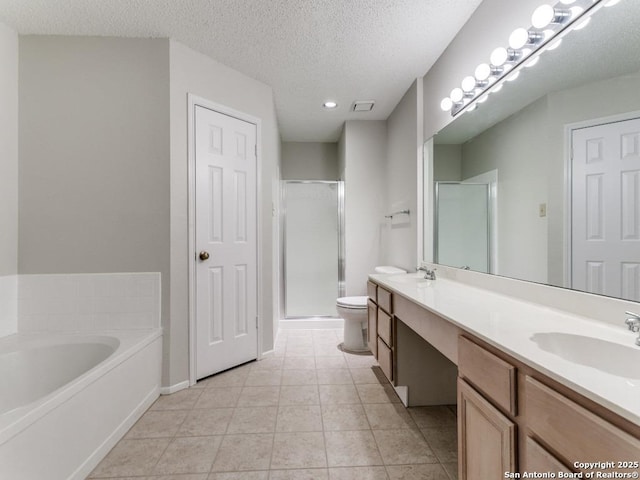 bathroom featuring a sink, a shower stall, a textured ceiling, and double vanity