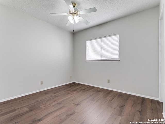 spare room featuring dark wood-style floors, ceiling fan, a textured ceiling, and baseboards