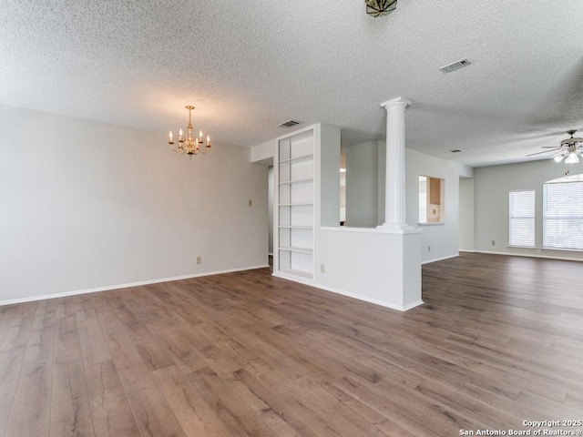 spare room with visible vents, decorative columns, and wood finished floors