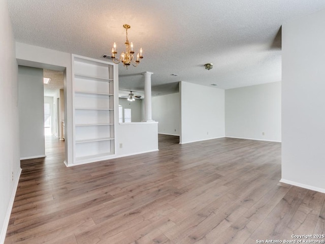 unfurnished room with ceiling fan with notable chandelier, visible vents, a textured ceiling, and wood finished floors