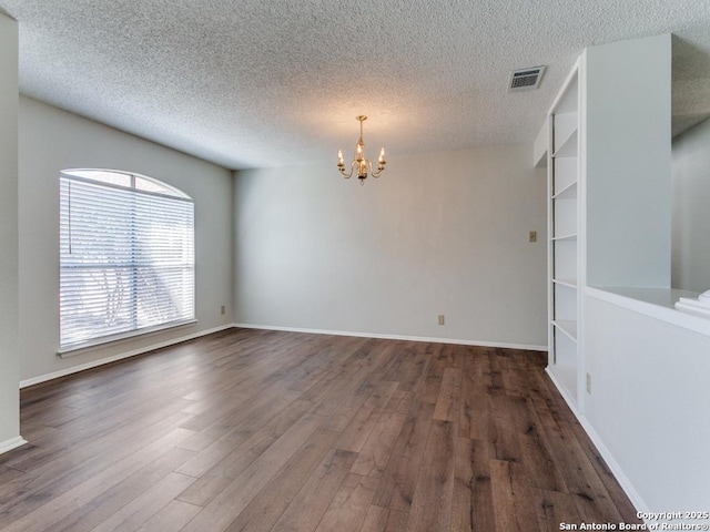 unfurnished room featuring baseboards, visible vents, a chandelier, and dark wood-type flooring