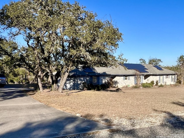 view of side of home with roof mounted solar panels