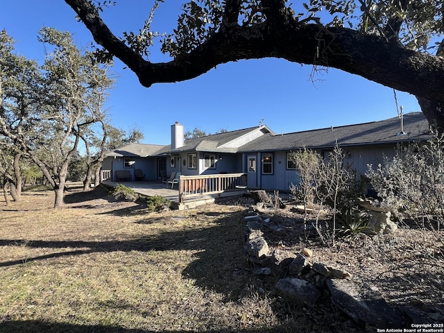 back of house with a patio and a chimney