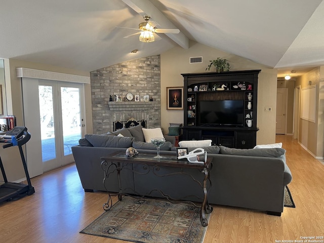 living room with visible vents, vaulted ceiling with beams, and light wood-style flooring