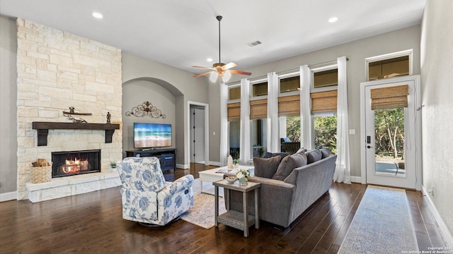 living room featuring baseboards, a fireplace, visible vents, and dark wood-type flooring