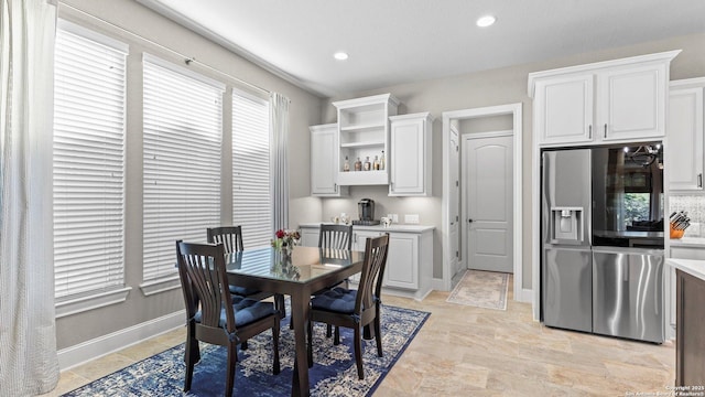 dining room with recessed lighting, bar, and baseboards