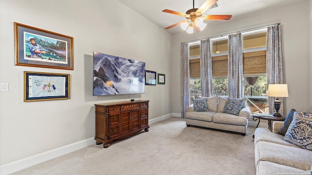 living area featuring vaulted ceiling, light carpet, ceiling fan, and baseboards