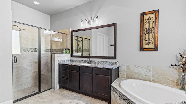 bathroom featuring a garden tub, a shower stall, and vanity