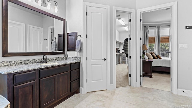 ensuite bathroom featuring visible vents, connected bathroom, and vanity